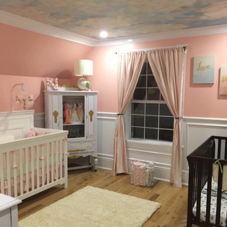 Nursery with a painted sky ceiling, pink walls, white wainscoting and two cribs