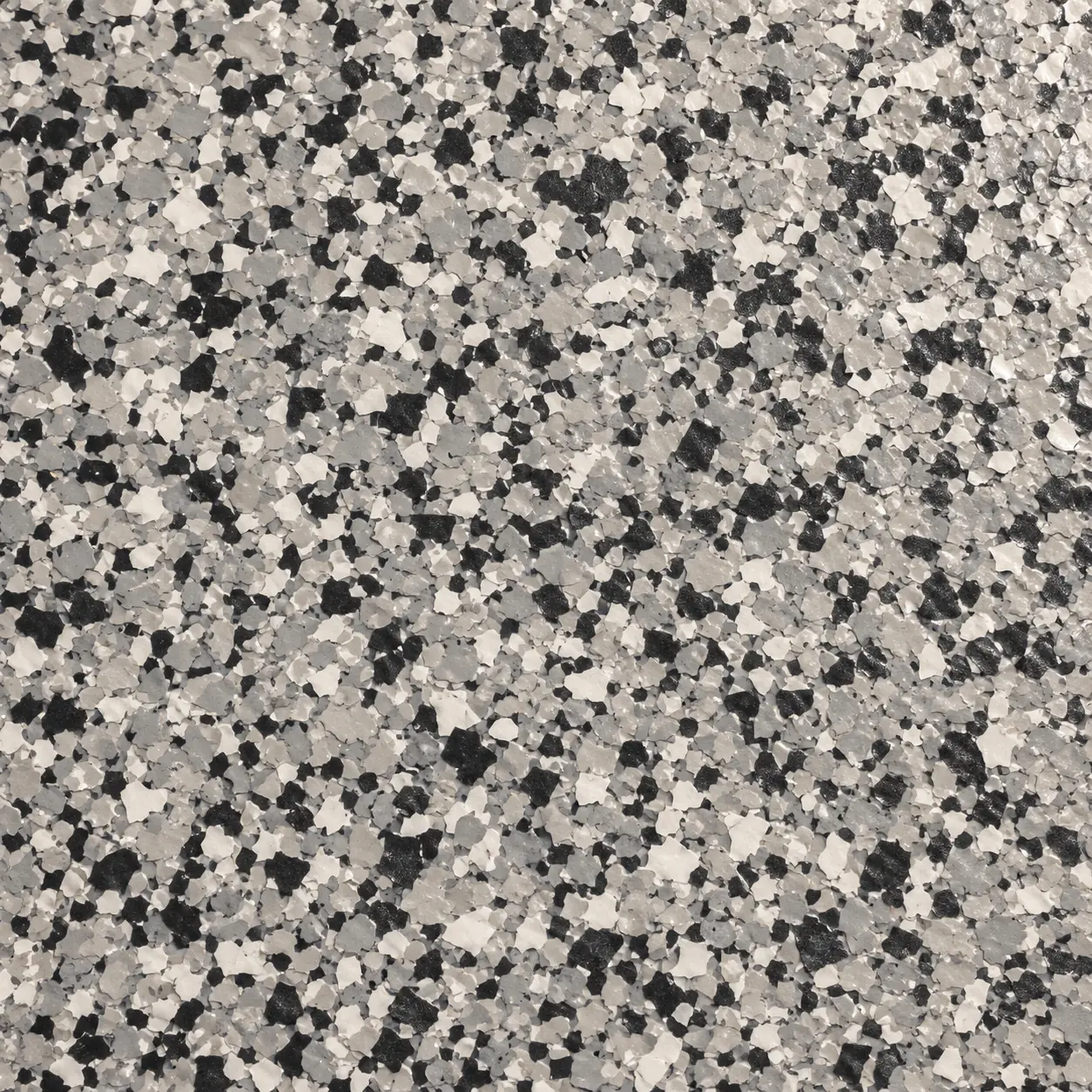 Close view of full-flake epoxy with black, white and grey chips under a clear coat