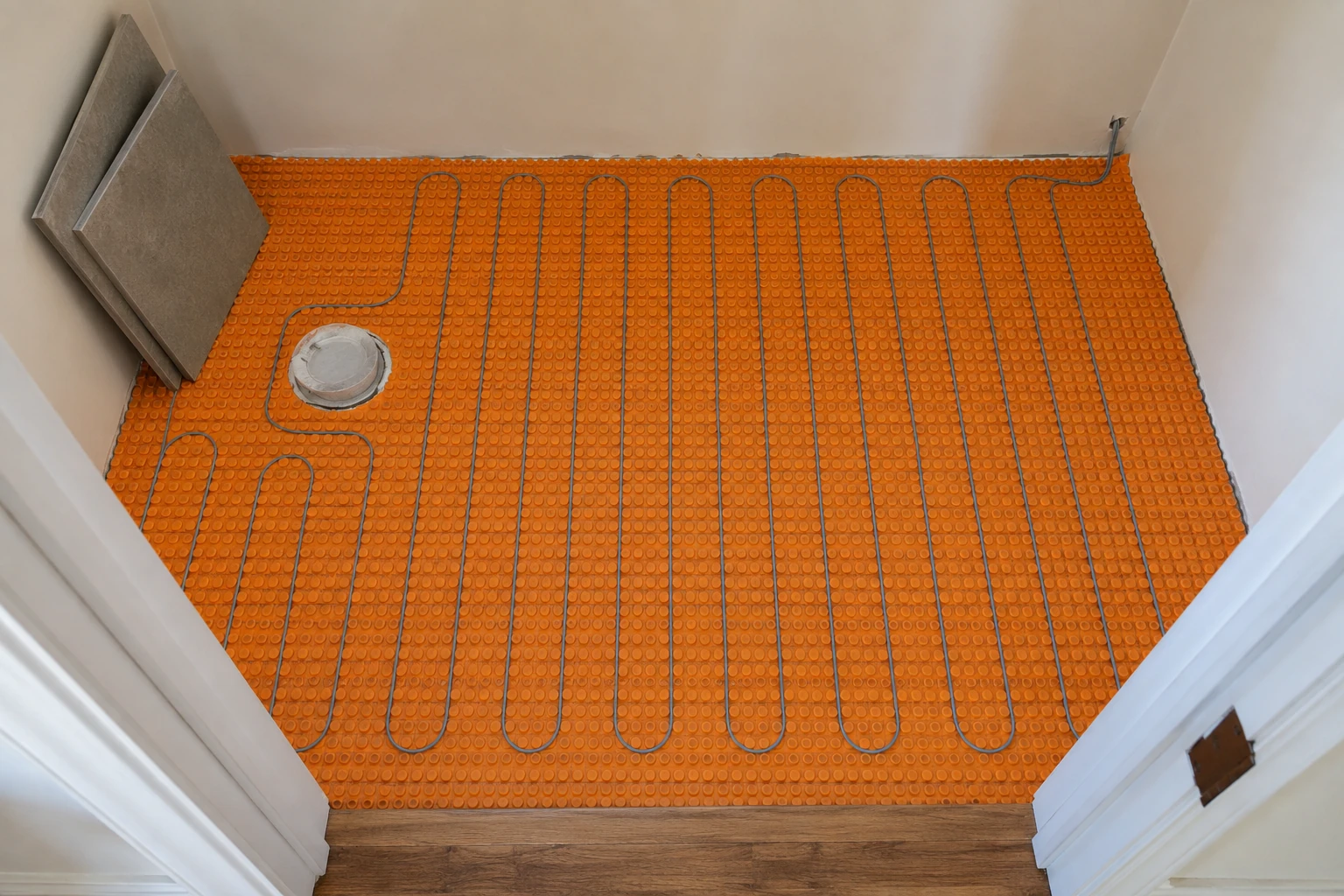 Heating cable laid in a serpentine pattern over an uncoupling membrane before tile goes down